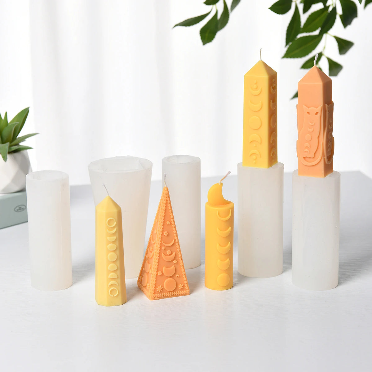 Five moon-phase pillar example candles displayed with their white silicone molds