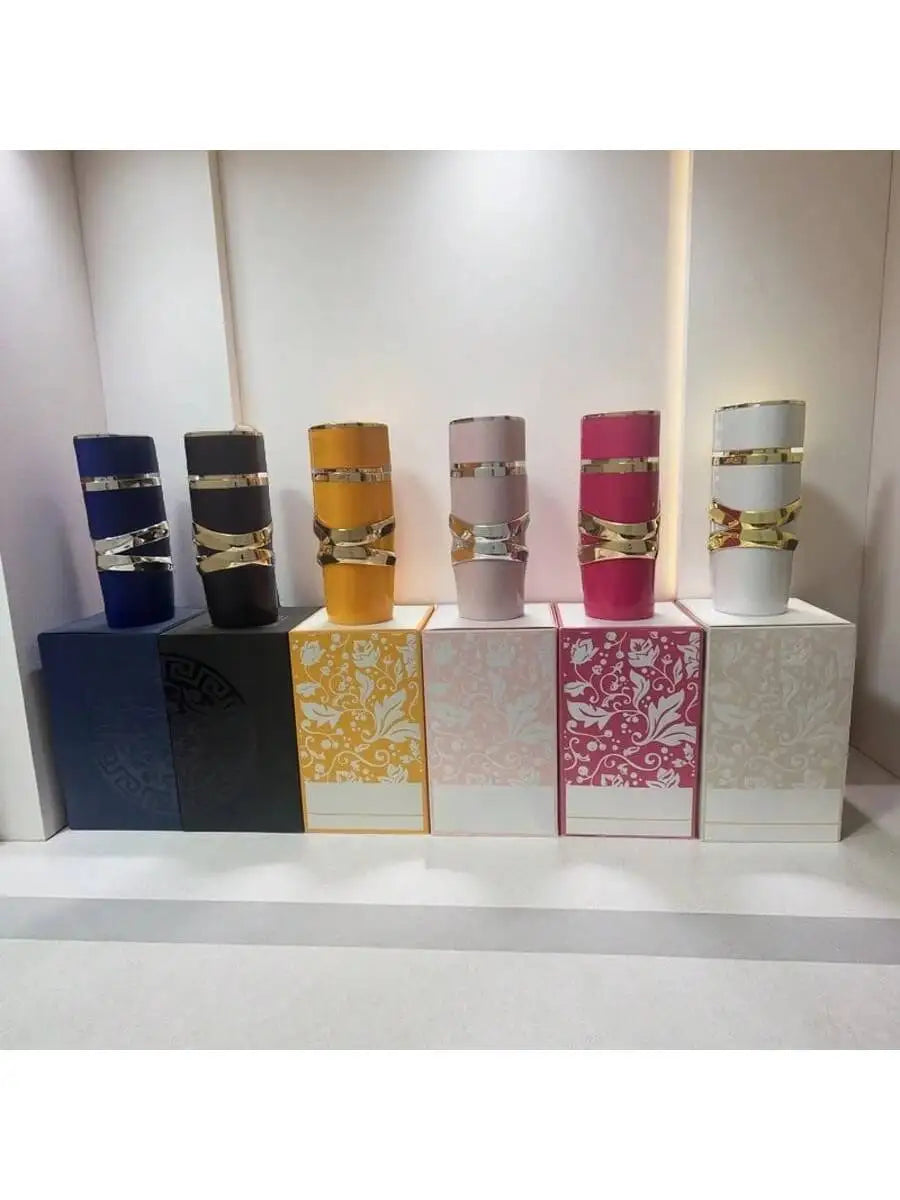 Set of colorful Lattafa Perfume cylindrical containers on a white shelf with decorative boxes.