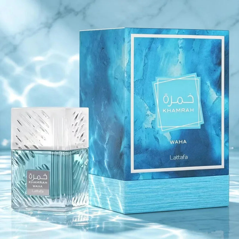 Lattafa Waha Khamrah perfume bottle and its blue marble-patterned box, displayed on a reflective light blue surface with a marble background.