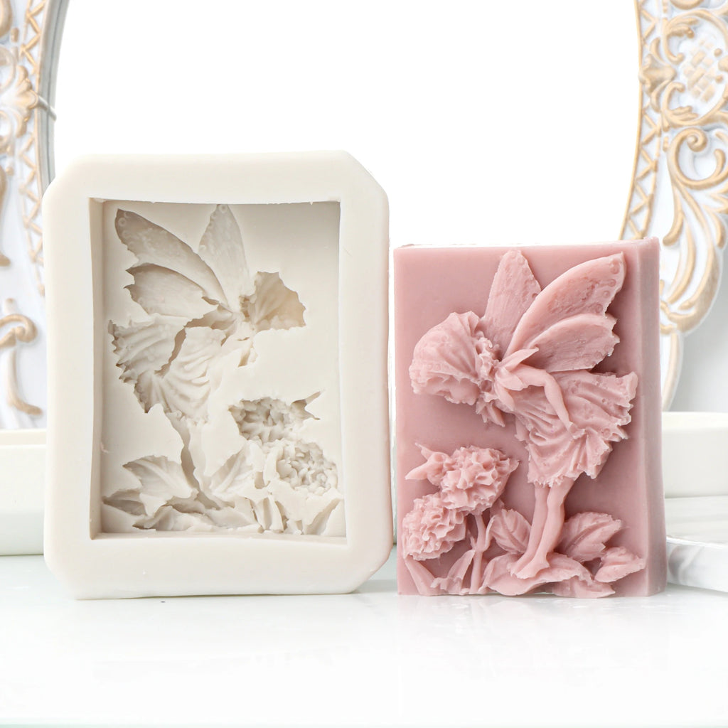 Rectangular pink standing fairy and flower relief casting example beside its white silicone mold
