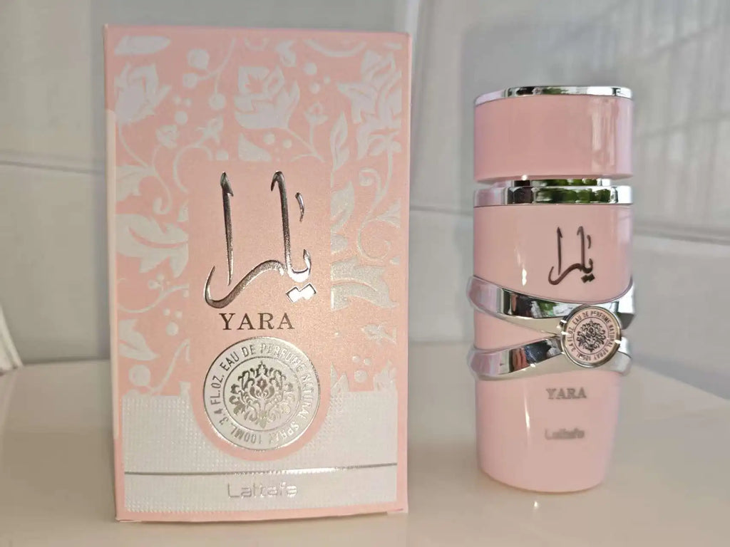 Pink Yara Lattafa Perfume perfume bottle and its matching pink patterned box on a light surface against a tiled background.