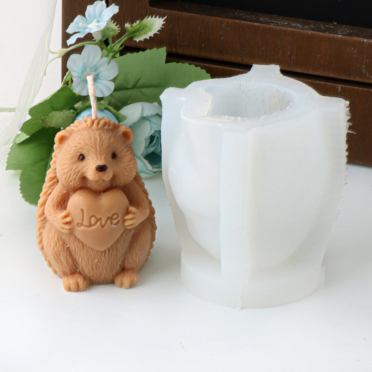 Tan hedgehog example candle holding a Love heart beside its white silicone mold
