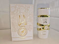 A white Lattafa Perfume perfume bottle with gold bands and Arabic lettering next to its matching white and gold outer box, labeled YARA and Laifan.