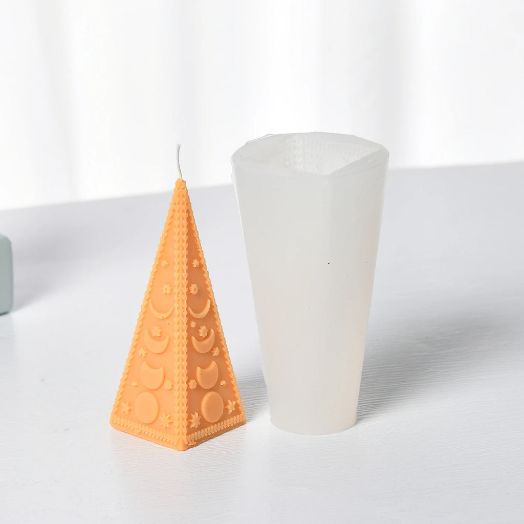 Orange triangular moon-phase example candle beside its white silicone mold