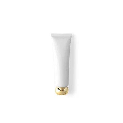 Single white squeeze tube with a rounded gold-tone screw cap