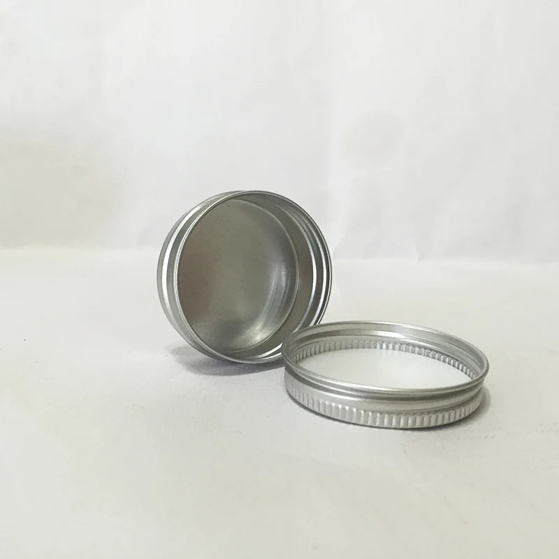 Open small silver aluminum tin and screw lid showing white inner liner