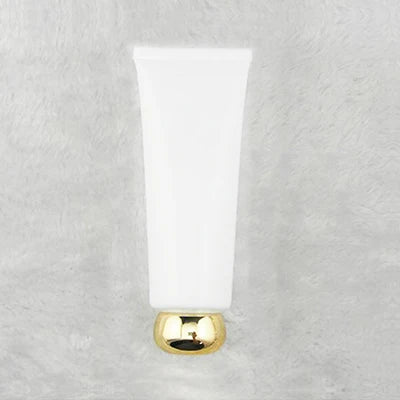 White squeeze tube with rounded gold-tone cap, style 14