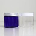 Blue empty jar with a silver-tone screw lid beside a clear jar with a white lid