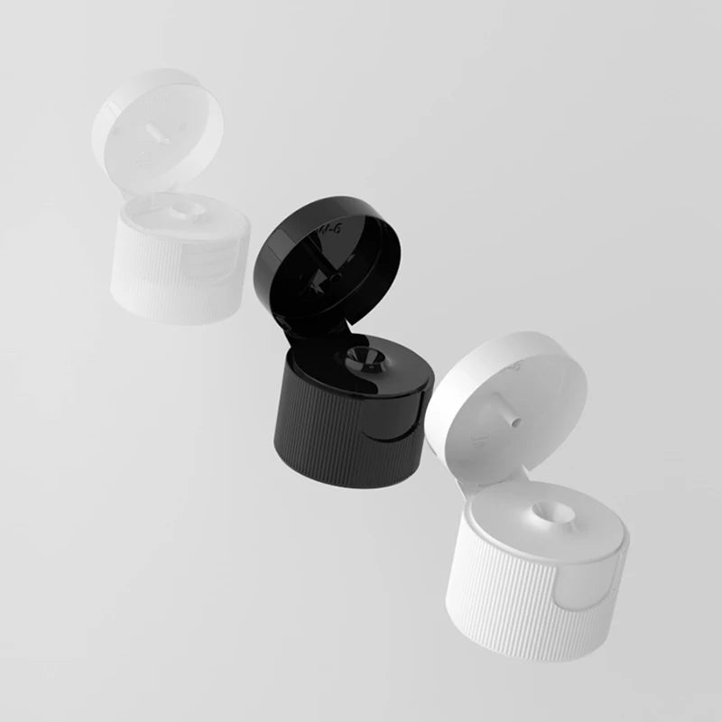 Black, white and translucent plastic flip-top bottle caps shown open