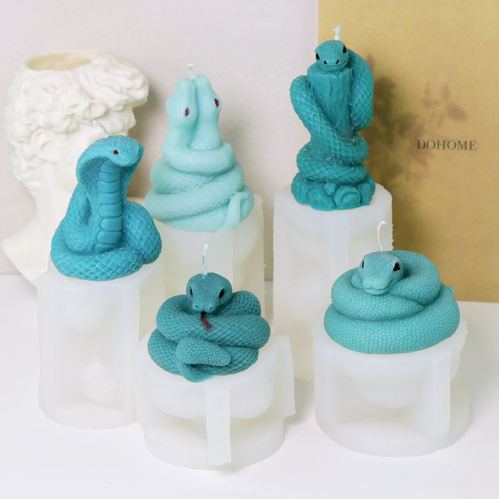 Five turquoise snake example candles displayed on their corresponding white silicone molds