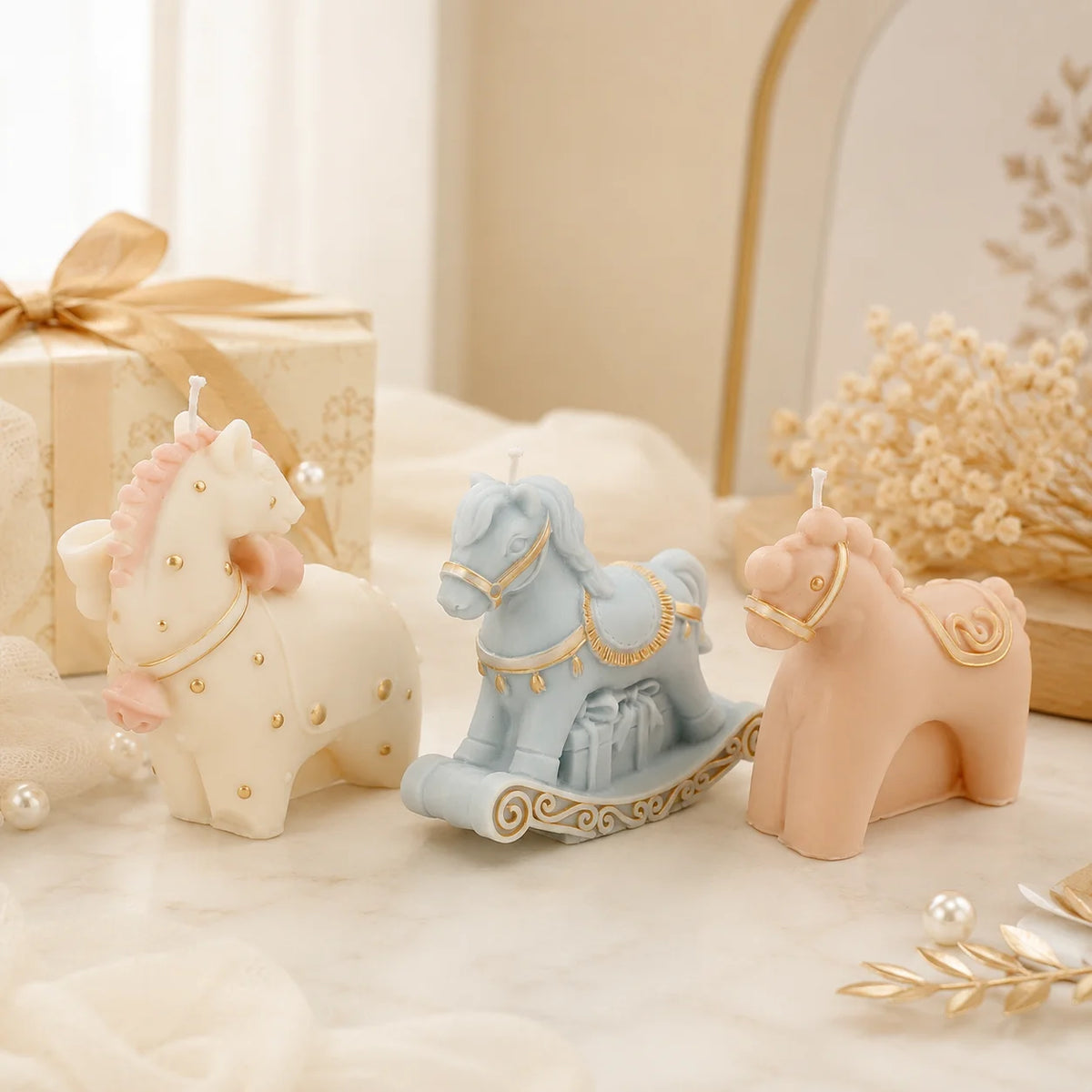 Three pastel horse example candles including a blue rocking horse, with gold-colored decorative accents