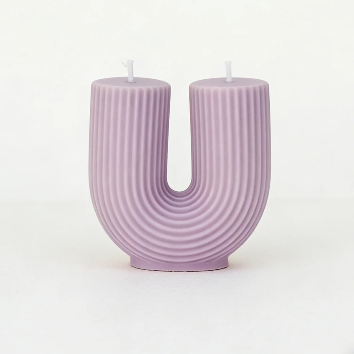 Purple candle shaped like the letter 'U' on a white background