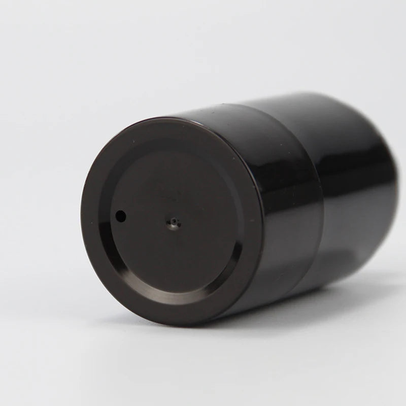 Close-up of the recessed base of a black airless-style spray container