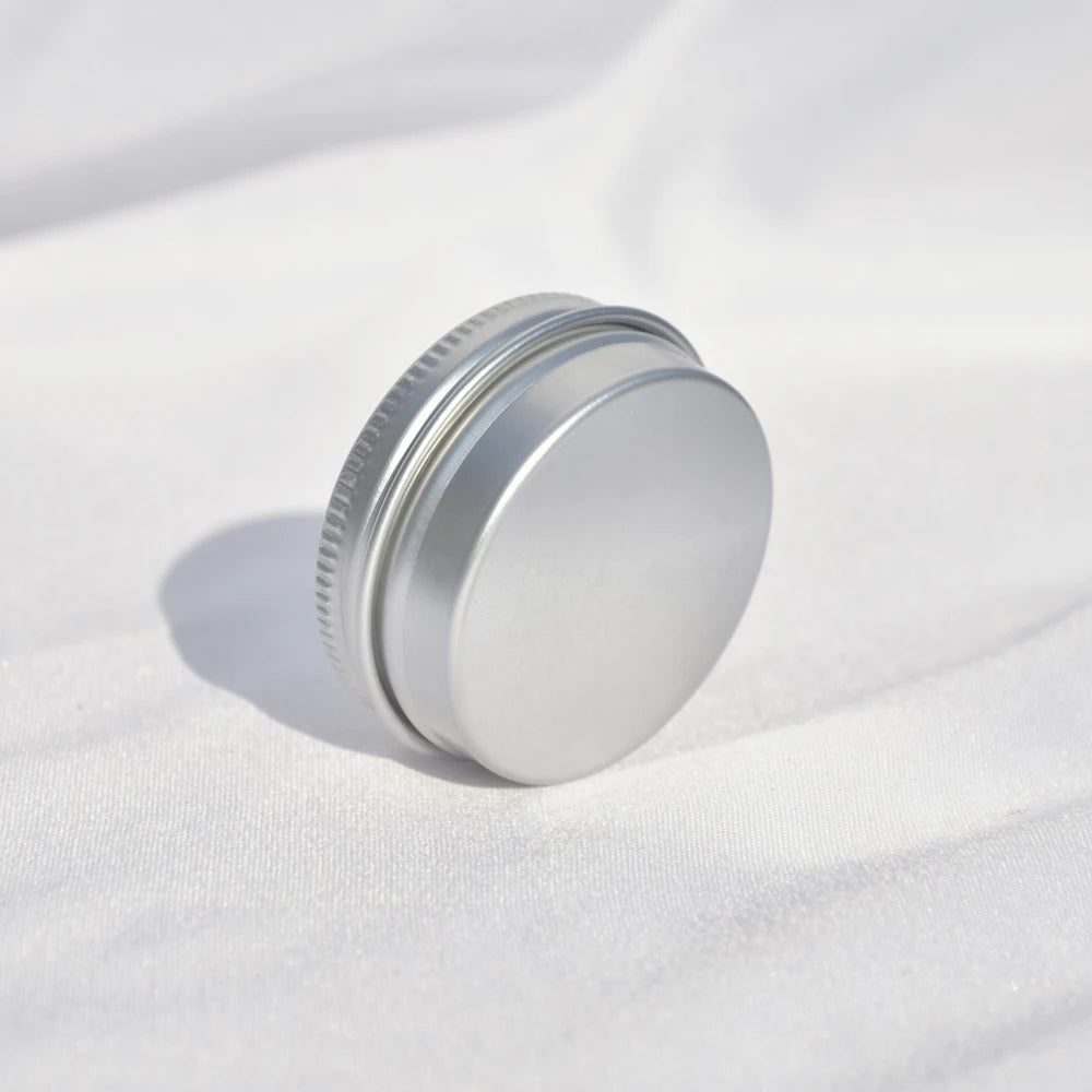 Small closed round silver tin resting on its edge