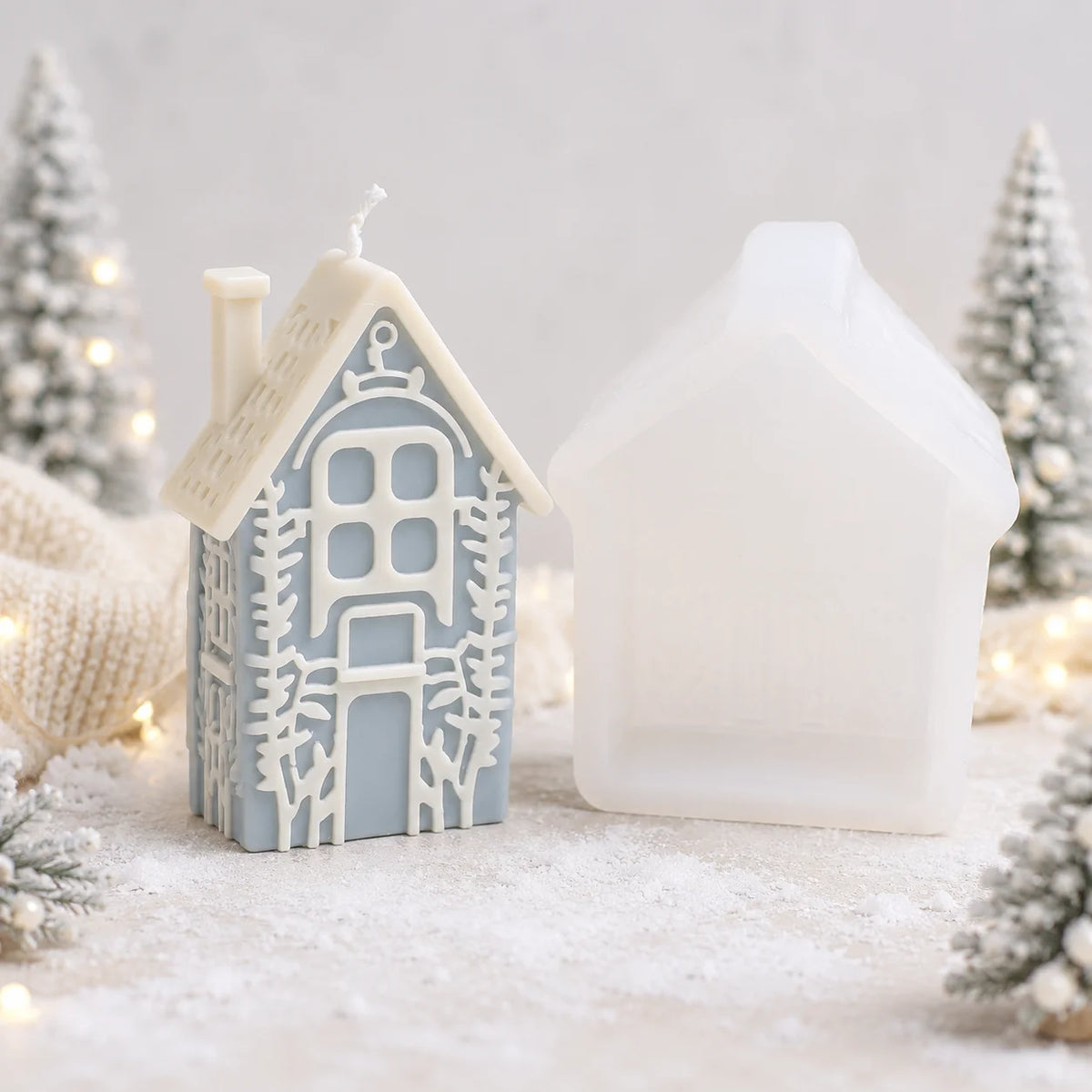 Tall blue-gray winter house example candle beside its white silicone mold