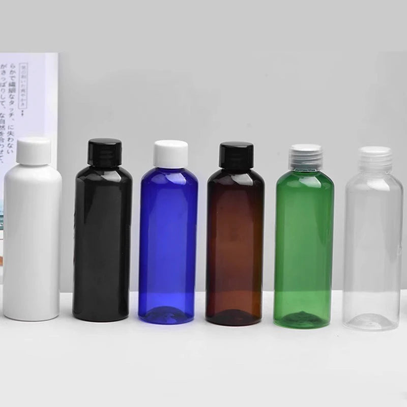 White, black, blue, brown, green and clear empty round bottles with screw caps