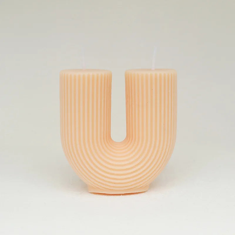 Decorative vase shaped like the letter 'U' with a ribbed texture on a light gray background