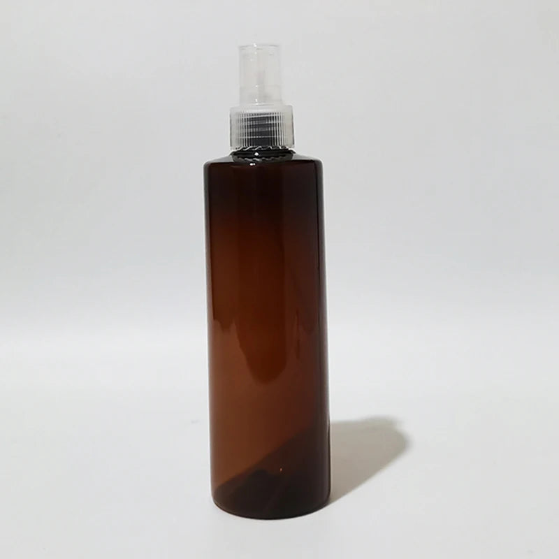 Brown empty round bottle with a translucent spray pump and clear cover