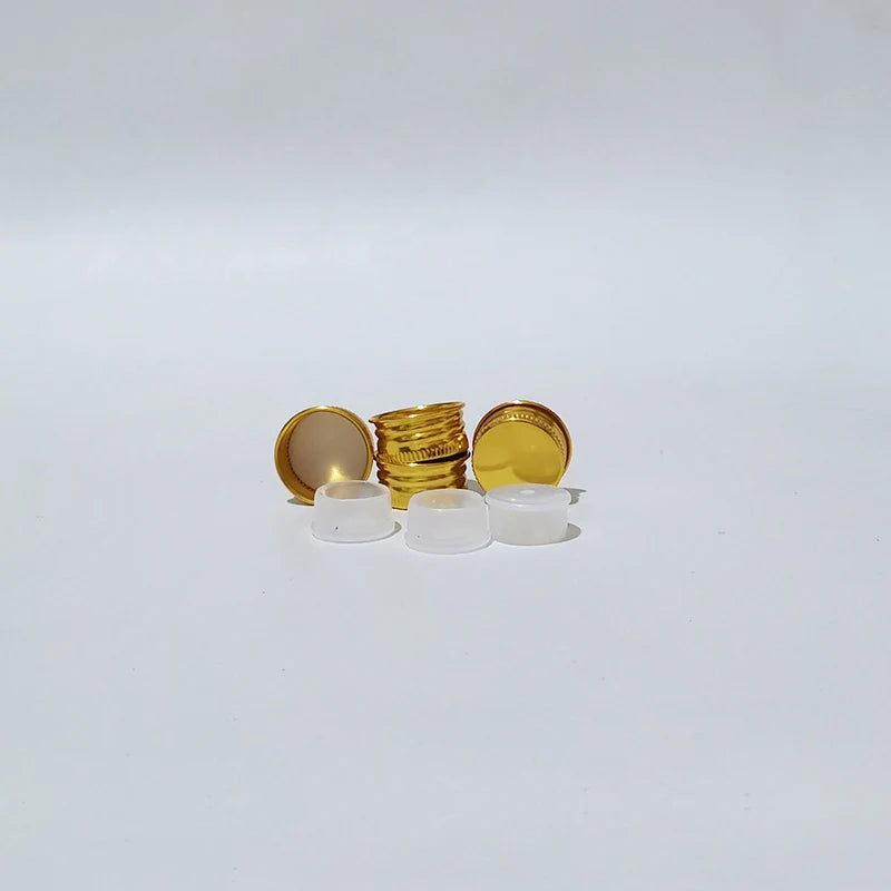 Gold-tone aluminum screw caps beside white inner components