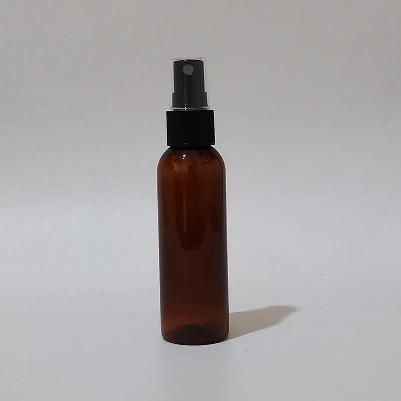 Brown round spray bottle with black sprayer and clear protective cap