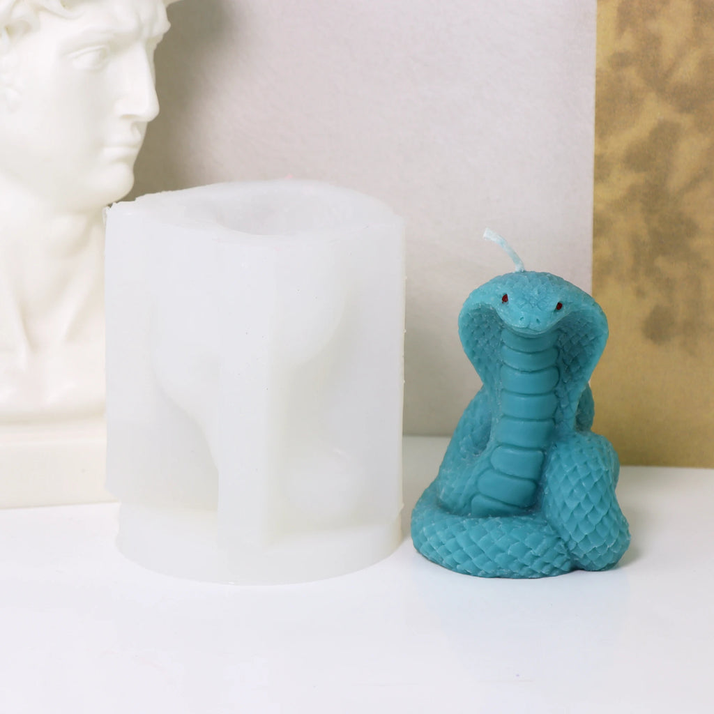 Turquoise hooded cobra example candle beside its white silicone mold