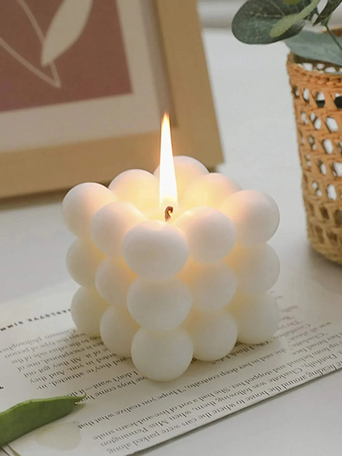 White bubble cube candle with rounded sections, shown lit on a tabletop