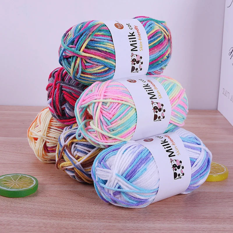 Stacked variegated yarn skeins in pastel and bright colorways on a wooden surface.