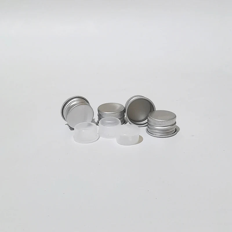 Silver aluminum screw caps beside white inner components