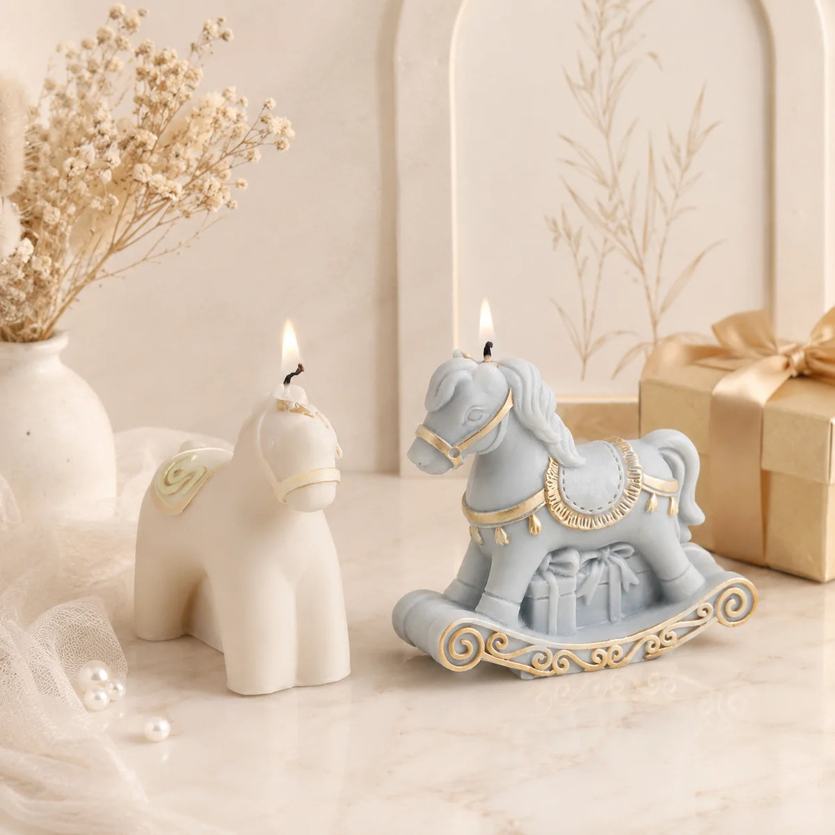 Lit ivory standing-horse and blue rocking-horse example candles with gold-colored trim