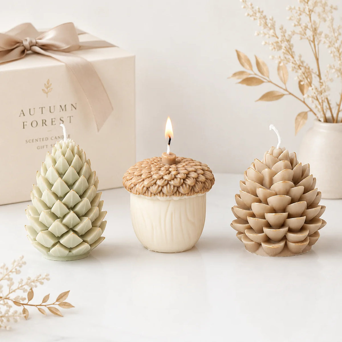 Two pinecone example candles flanking a lit ivory acorn candle with a textured brown cap