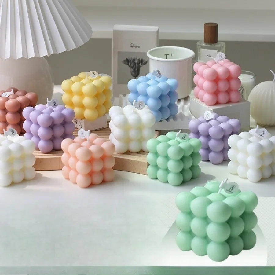 Pastel bubble cube candles arranged at different heights on a decorative tabletop