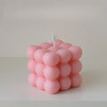 Pink bubble cube candle with rounded sections and a tall unlit wick