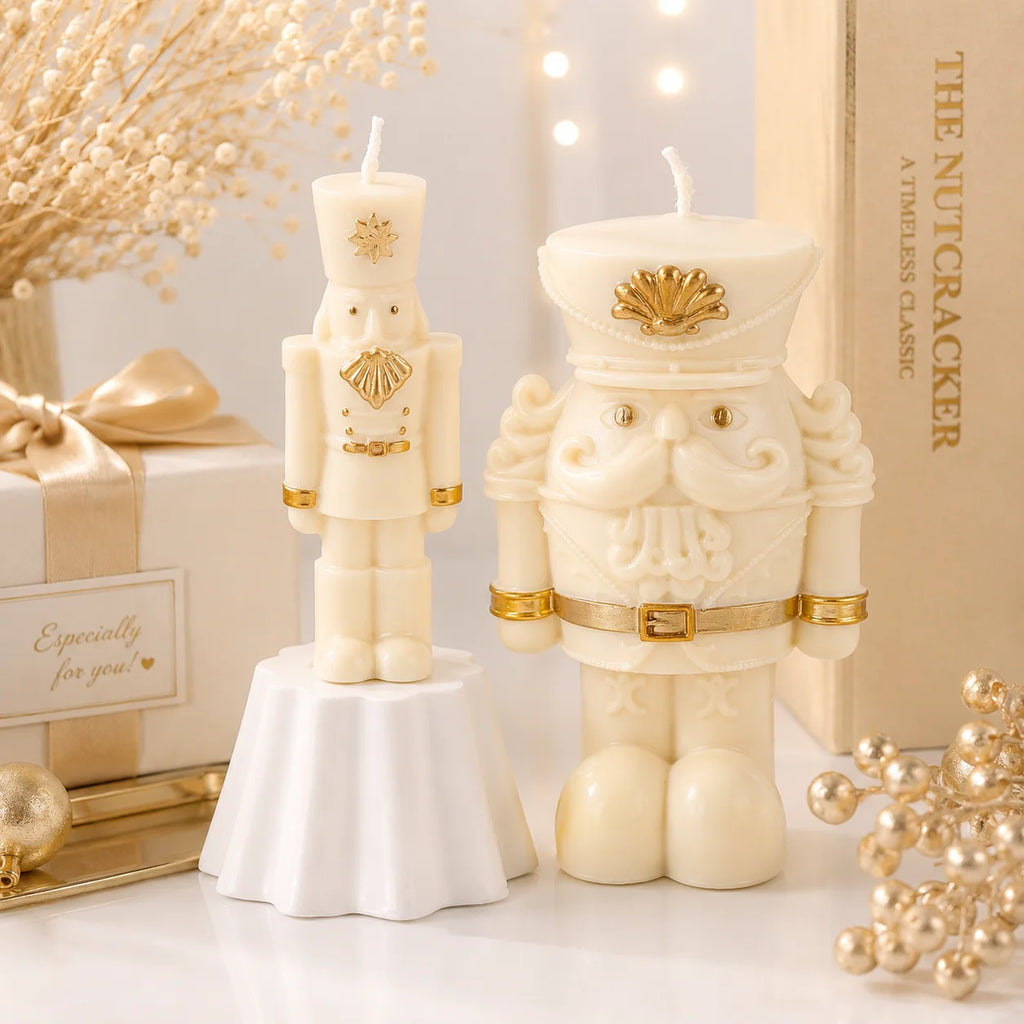 Slender and wide-bodied ivory nutcracker example candles with gold-colored hat and beard details