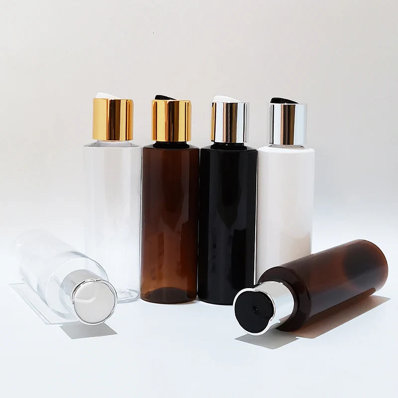 Empty round bottles with gold-tone and silver-tone disc caps, standing and lying down