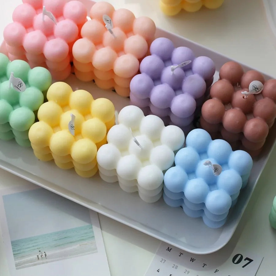Bubble cube candles in pastel pink, peach, green, yellow, white, blue and purple arranged on a tray