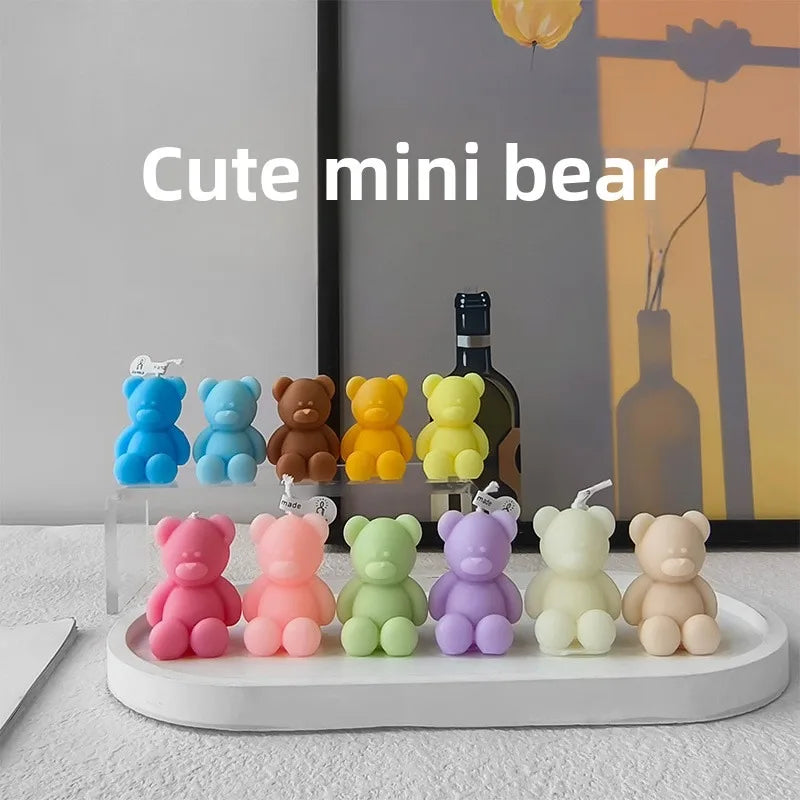 Mini teddy bear candles in assorted colors arranged on a white display tray