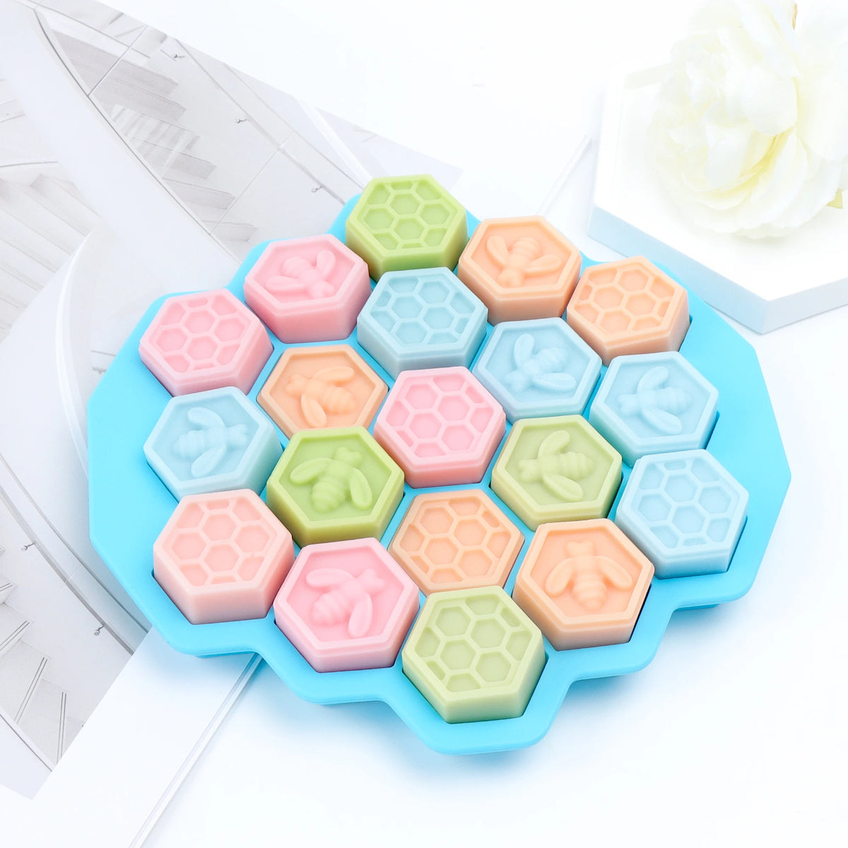 Blue multi-cavity hexagonal mold filled with pastel bee and honeycomb example castings