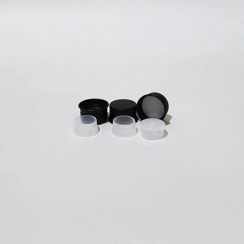 Black aluminum screw caps beside white inner components