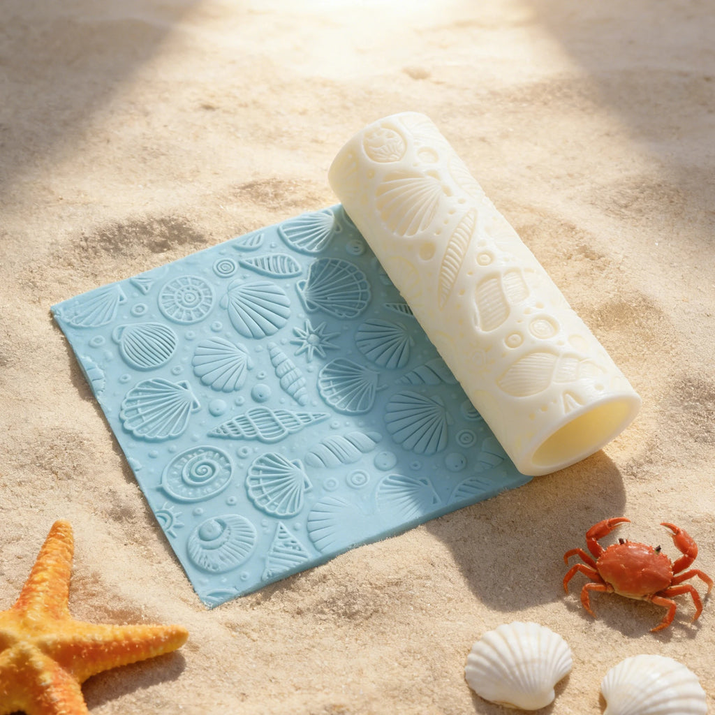 Angled view of a seashell embossing roller resting along a blue coastal relief panel