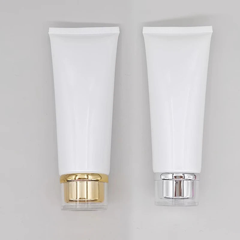 White squeeze tubes with gold-tone and silver-tone stepped cap assemblies
