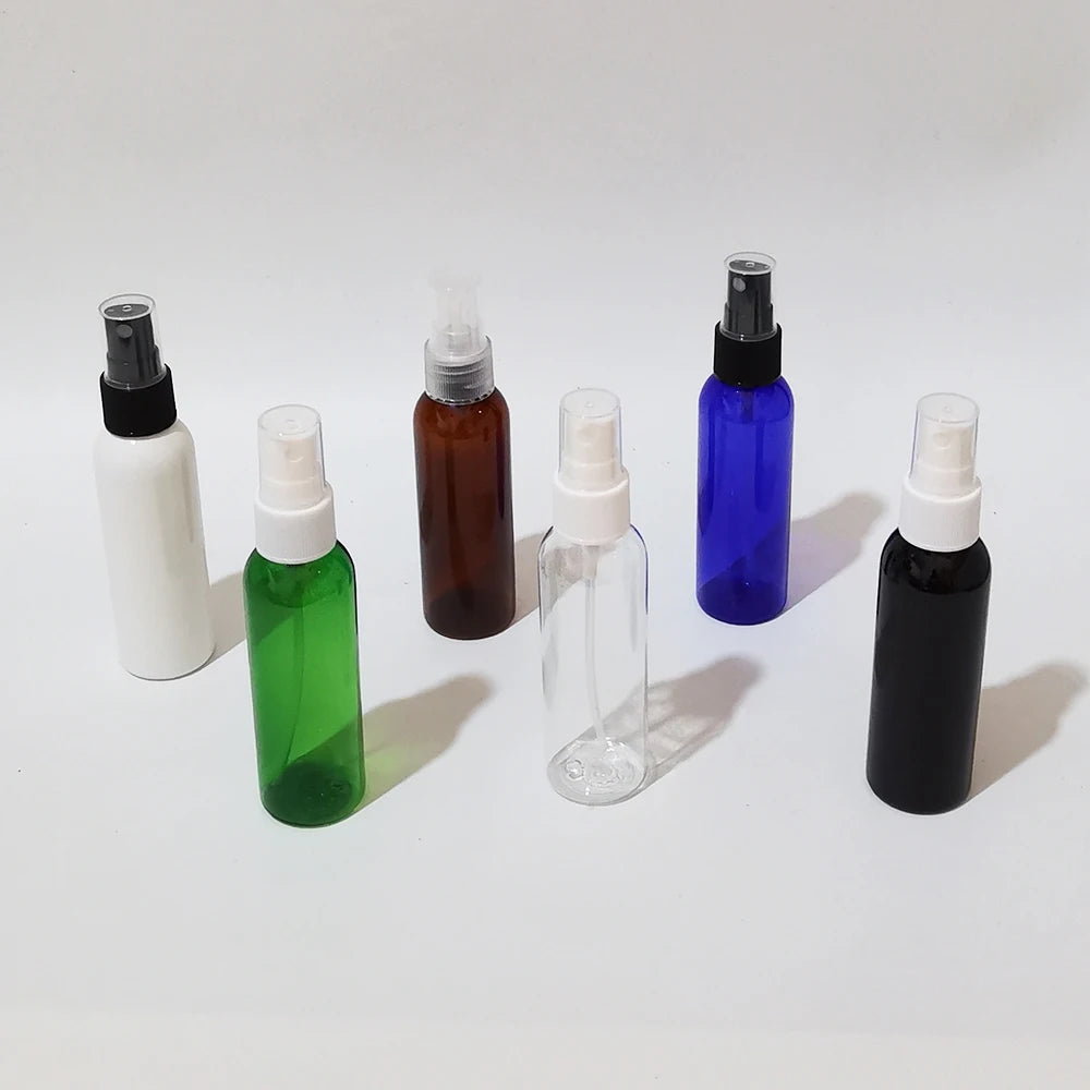 Assorted black, white, clear, green, blue and brown empty spray bottles with protective caps