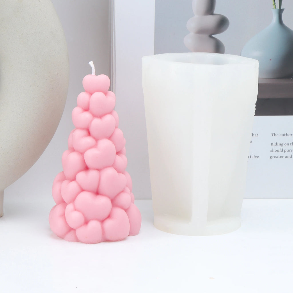 Pink clustered-heart example candle beside its white silicone pillar mold