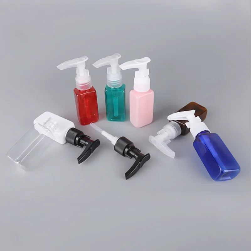 Small colored rectangular PET bottles arranged with black, white and clear pump dispensers