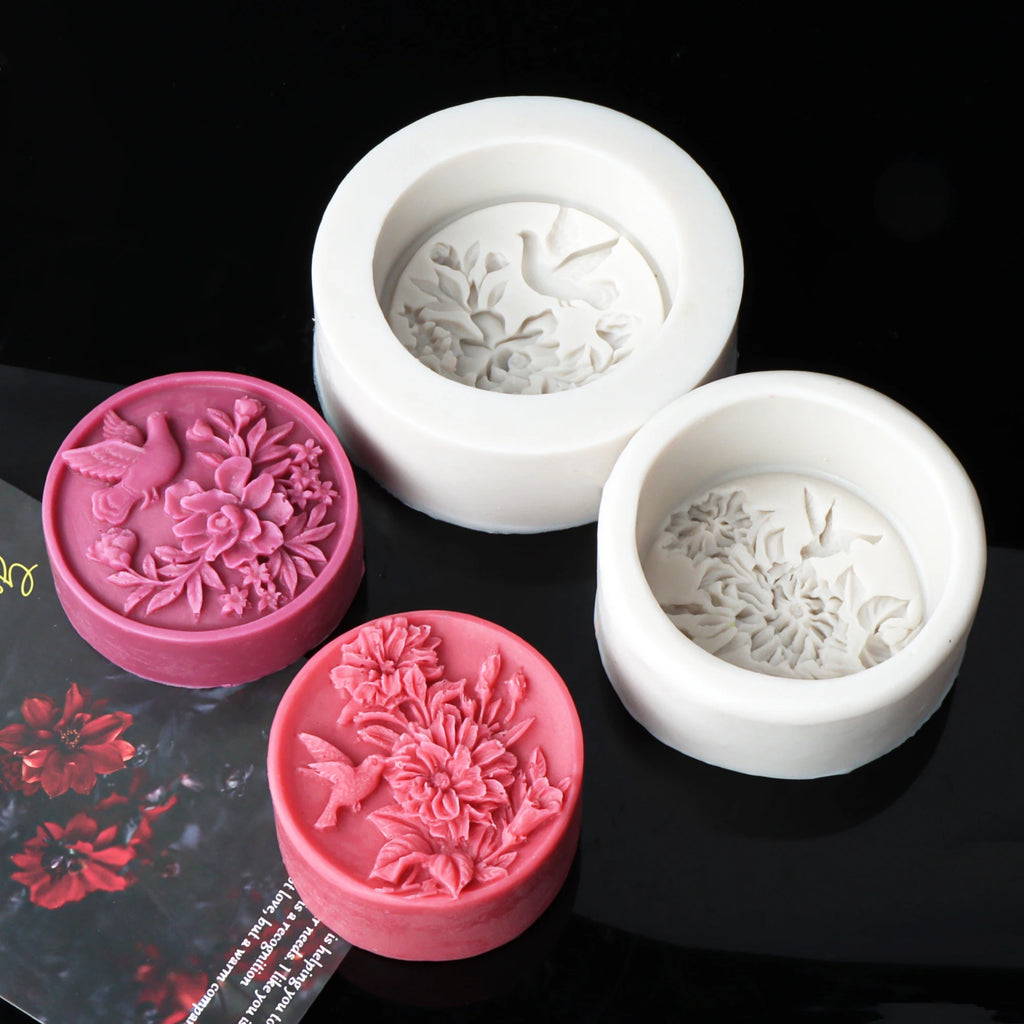 Pink and magenta round bird-and-flower relief casting examples beside white silicone molds