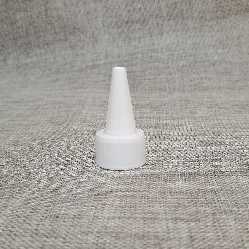 Single white pointed-nozzle bottle closure on textured fabric