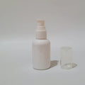White empty round bottle with a white pump and clear protective cover beside it