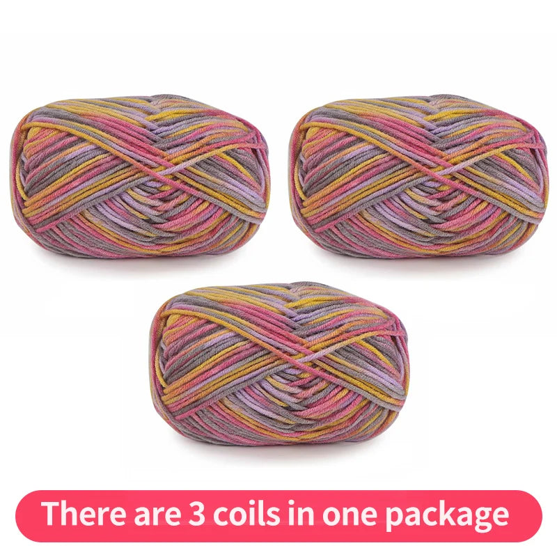 Three variegated yarn skeins in pink, mauve, gray and mustard yellow, shown as one package.
