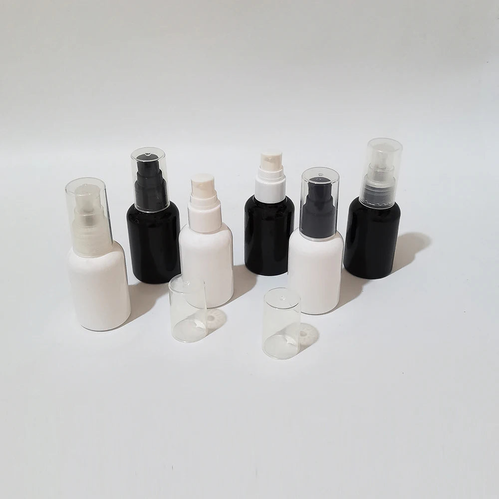 Angled view of black and white empty bottles with pump closures and clear covers