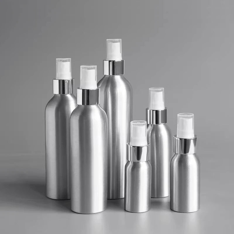 Assorted silver aluminum bottles with white sprayers and clear covers