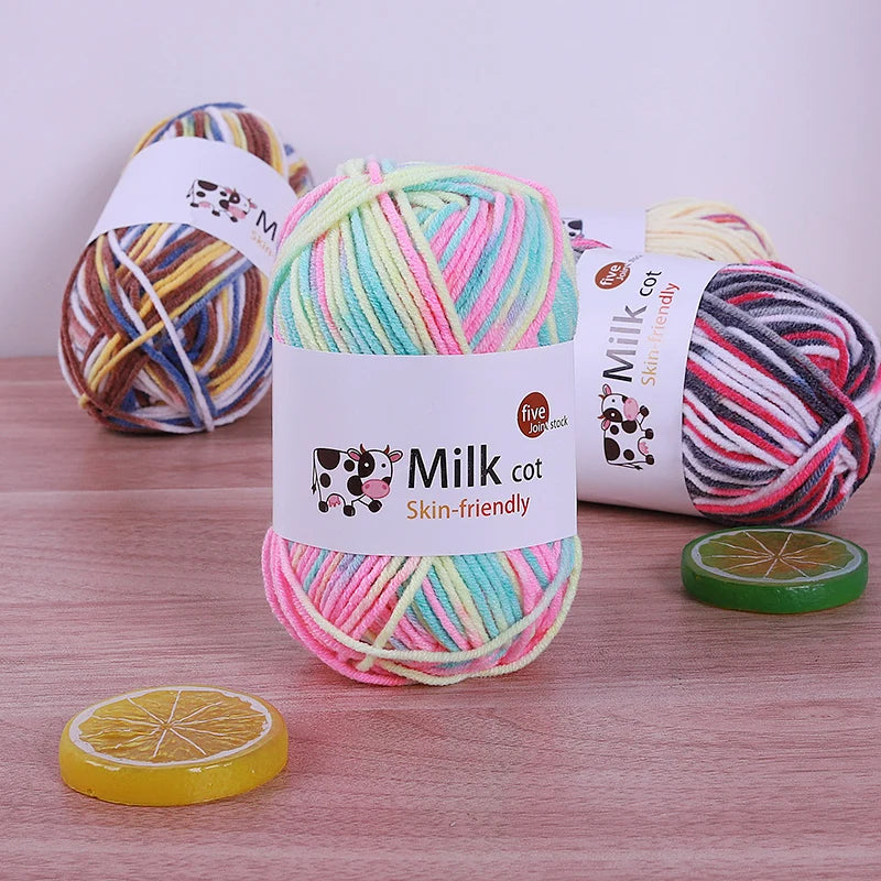 Pink, mint, yellow and white yarn skein with other variegated colorways behind it.